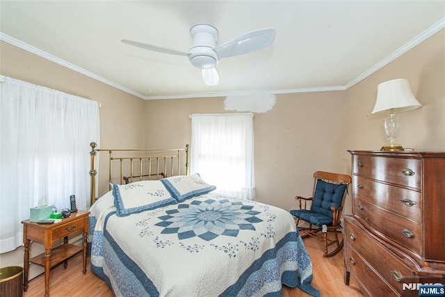 bedroom with ornamental molding, light wood-type flooring, and a ceiling fan