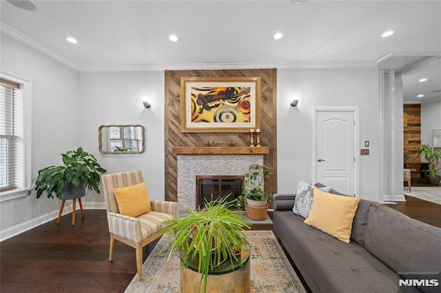 living area with baseboards, dark wood-style flooring, crown molding, a fireplace, and recessed lighting