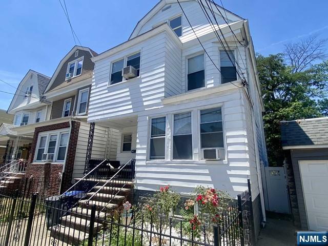 view of front of house with fence, cooling unit, and a gambrel roof