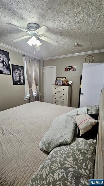 bedroom with a textured ceiling, ceiling fan, and ornamental molding