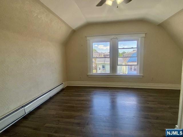 bonus room with dark wood-style flooring, vaulted ceiling, and baseboard heating