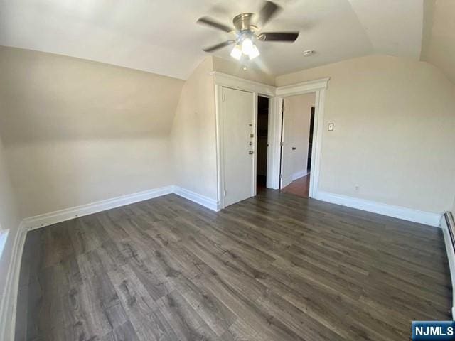 additional living space with a ceiling fan, baseboards, vaulted ceiling, and dark wood-type flooring