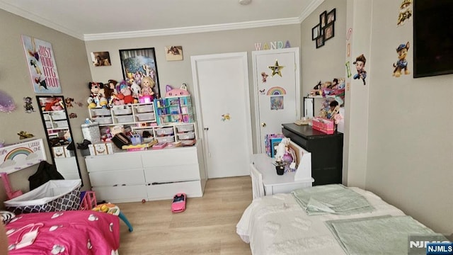 bedroom featuring ornamental molding and wood finished floors