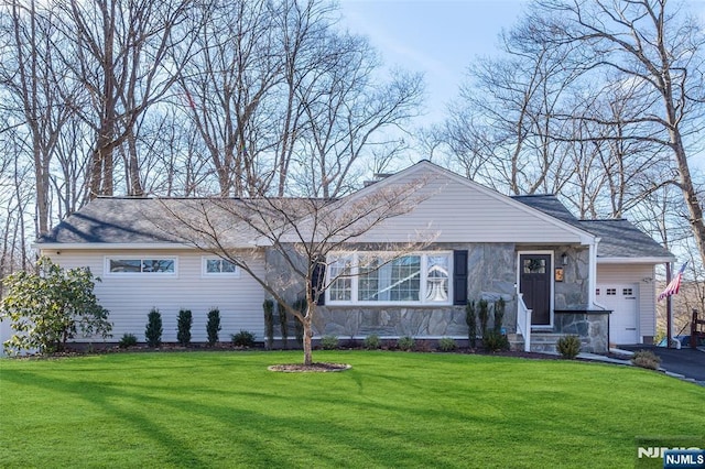 ranch-style home featuring a garage, a front lawn, and aphalt driveway