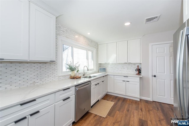 kitchen with light stone countertops, white cabinetry, visible vents, and appliances with stainless steel finishes