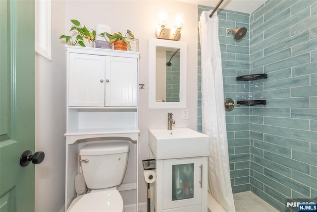 full bath featuring tiled shower, vanity, and toilet