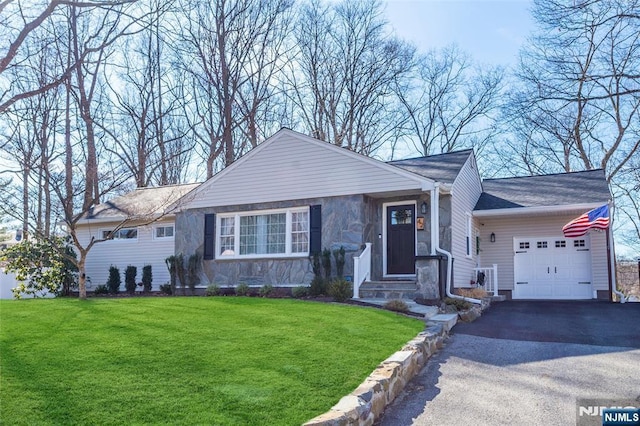 view of front of property featuring a garage, stone siding, driveway, and a front lawn