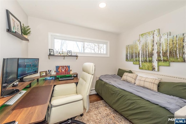 bedroom featuring baseboard heating, wood finished floors, and recessed lighting