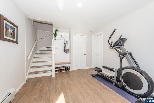 exercise area featuring a baseboard heating unit, recessed lighting, baseboards, and wood finished floors