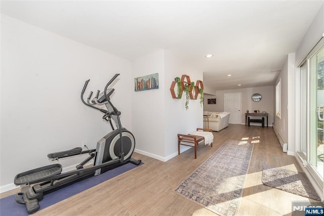 exercise room with baseboards, recessed lighting, a baseboard radiator, and light wood-style floors