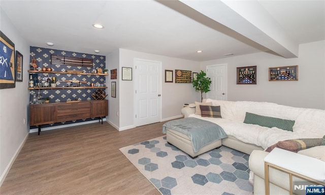 living area featuring recessed lighting, wood finished floors, visible vents, baseboards, and beam ceiling