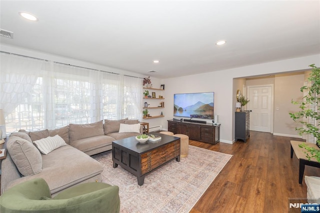 living area featuring recessed lighting, visible vents, baseboards, and wood finished floors