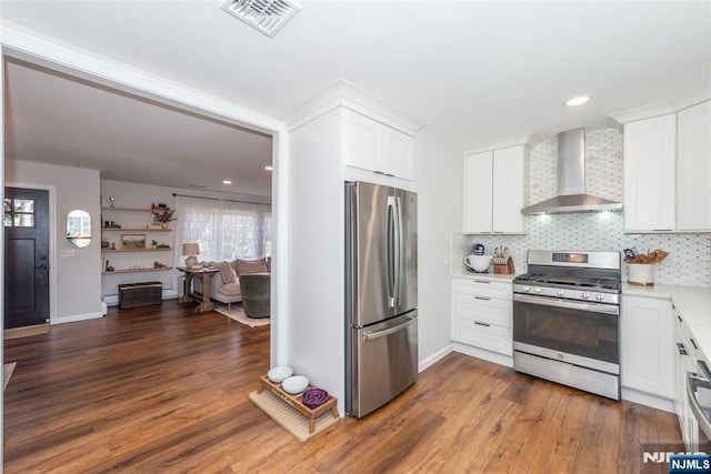 kitchen with tasteful backsplash, visible vents, stainless steel appliances, light countertops, and wall chimney range hood