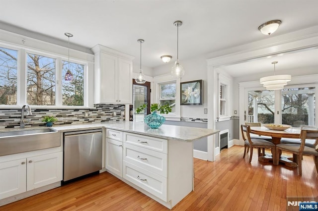 kitchen featuring white cabinets, dishwasher, radiator, backsplash, and a sink