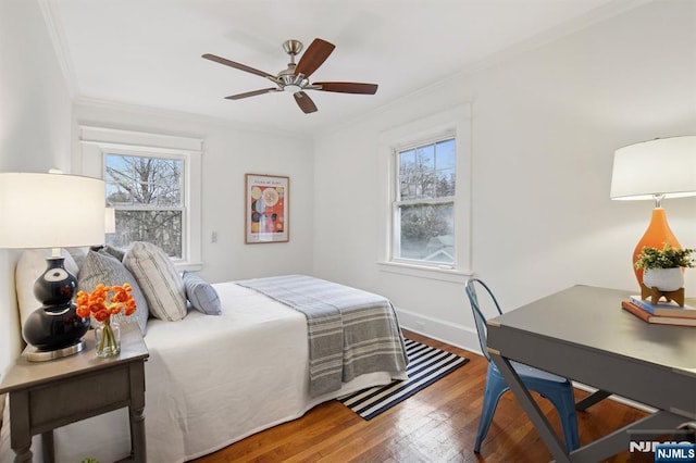 bedroom featuring ornamental molding, multiple windows, wood finished floors, and baseboards