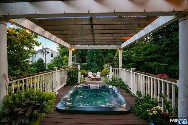 wooden terrace featuring hot tub deck surround and a pergola