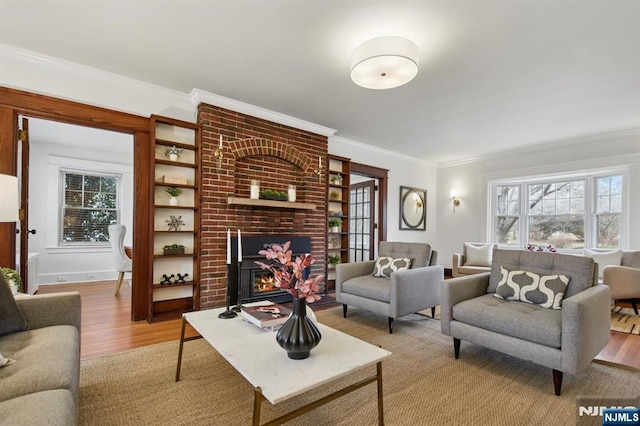 living room with light wood finished floors, plenty of natural light, a fireplace, and ornamental molding