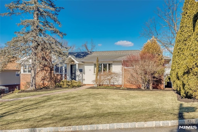 ranch-style home with a front yard and brick siding