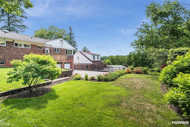 view of yard with a garage and driveway