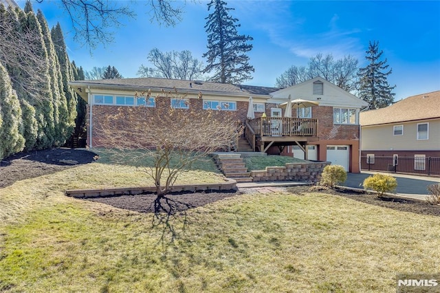 rear view of property with driveway, stairway, a lawn, and brick siding