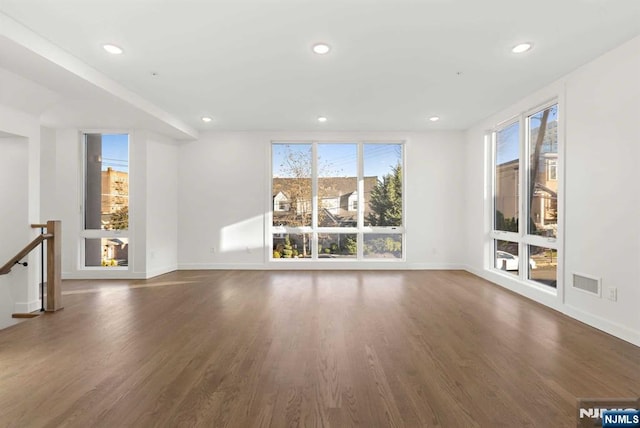 unfurnished living room with wood finished floors, visible vents, and recessed lighting