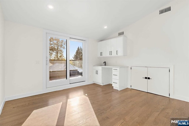 interior space with light wood finished floors, recessed lighting, visible vents, and baseboards