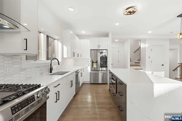 kitchen with stainless steel appliances, white cabinets, a kitchen island, a sink, and modern cabinets