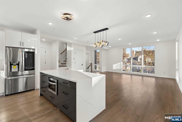 kitchen featuring recessed lighting, wood finished floors, hanging light fixtures, appliances with stainless steel finishes, and modern cabinets