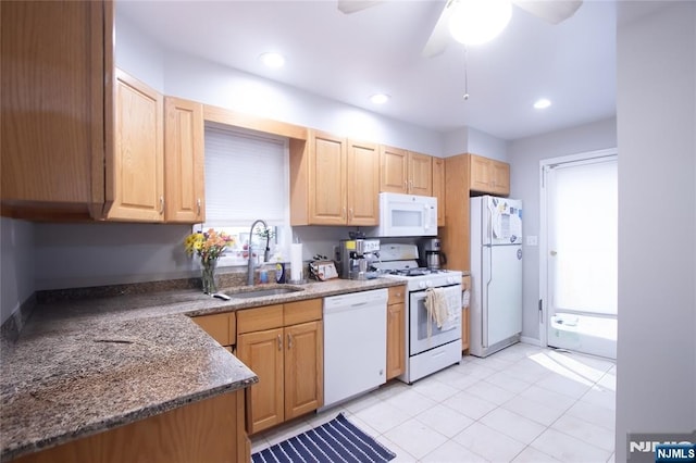 kitchen with light tile patterned flooring, recessed lighting, white appliances, a sink, and light brown cabinetry