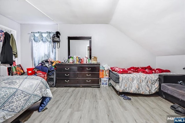 bedroom with lofted ceiling and wood finished floors