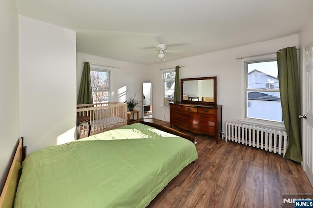 bedroom with radiator heating unit, a ceiling fan, and wood finished floors