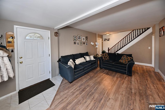 living area with wood finished floors, baseboards, and stairs