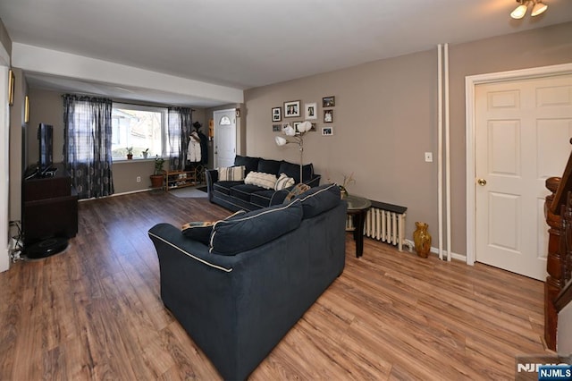 living room featuring radiator, baseboards, and wood finished floors