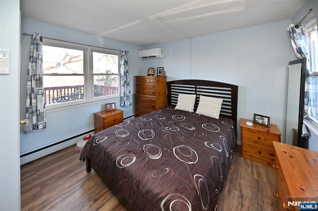 bedroom with a baseboard heating unit, wood finished floors, and a wall mounted AC