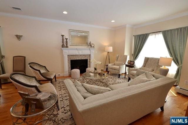 living room featuring recessed lighting, a fireplace, wood finished floors, visible vents, and ornamental molding