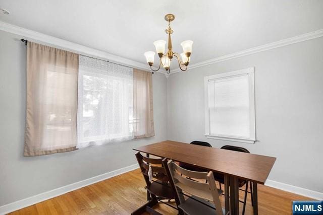 dining room with crown molding, wood finished floors, and baseboards