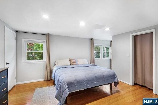 bedroom with light wood-style floors, baseboards, and recessed lighting