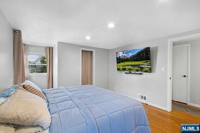 bedroom featuring recessed lighting, wood finished floors, visible vents, and baseboards