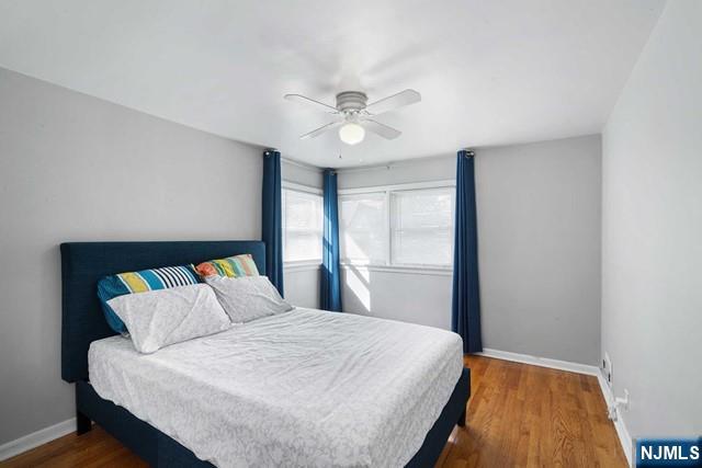 bedroom with wood finished floors, a ceiling fan, and baseboards