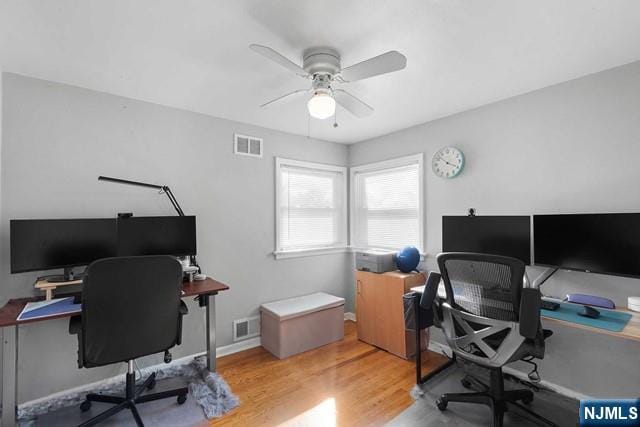 office space with visible vents, ceiling fan, and wood finished floors