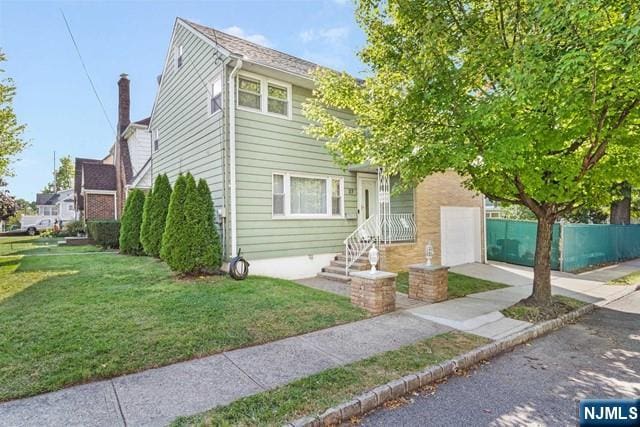 view of front of property with a garage, a front yard, and fence