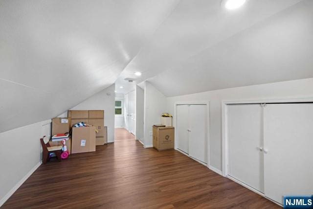 additional living space featuring lofted ceiling, wood finished floors, and baseboards