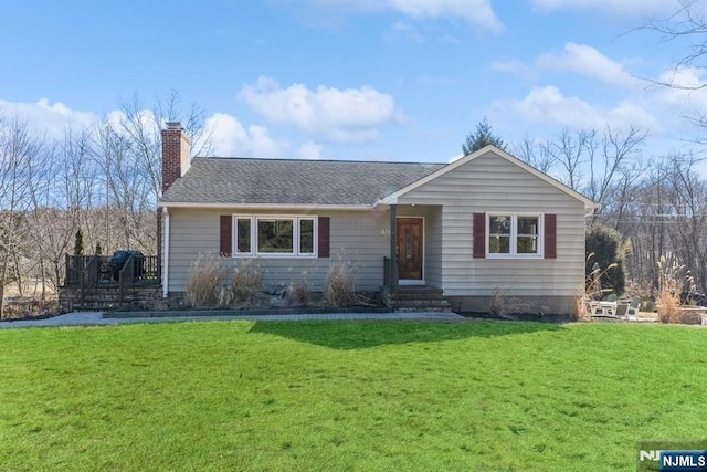 single story home featuring a shingled roof, a chimney, and a front yard