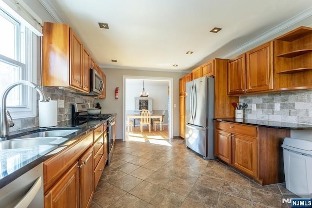 kitchen featuring open shelves, appliances with stainless steel finishes, a sink, and brown cabinets