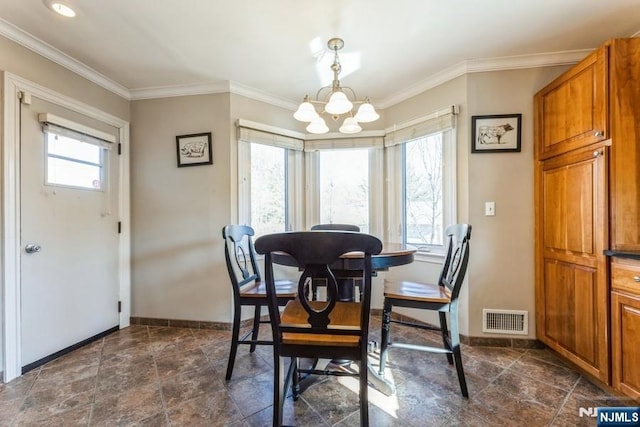 dining area with a chandelier, visible vents, ornamental molding, and baseboards