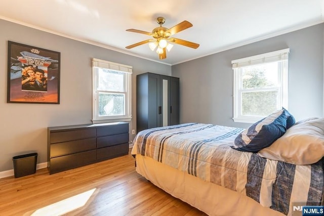 bedroom with ornamental molding, multiple windows, and light wood-type flooring