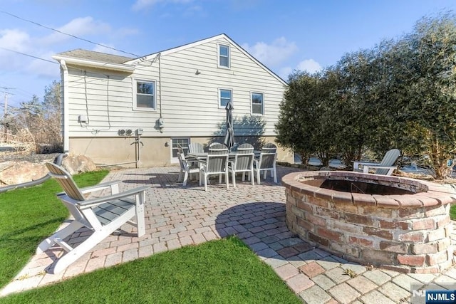 rear view of house with a patio area and an outdoor fire pit