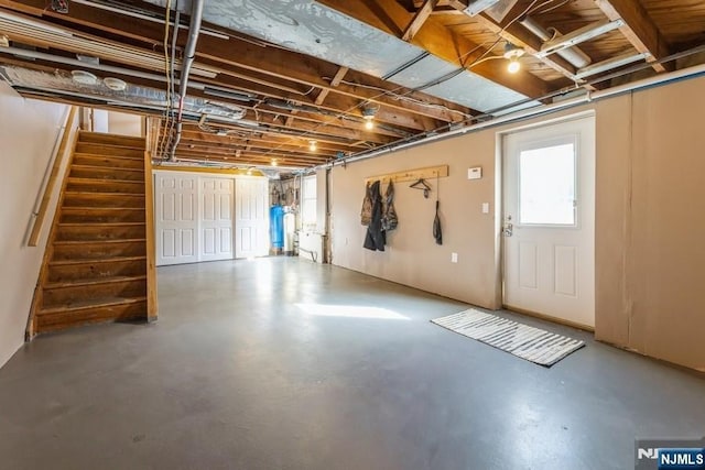 basement with water heater and stairs