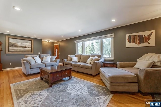 living area featuring light wood-style floors, recessed lighting, crown molding, and baseboards