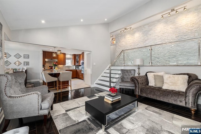 living area with light wood-type flooring, high vaulted ceiling, recessed lighting, stairway, and baseboards